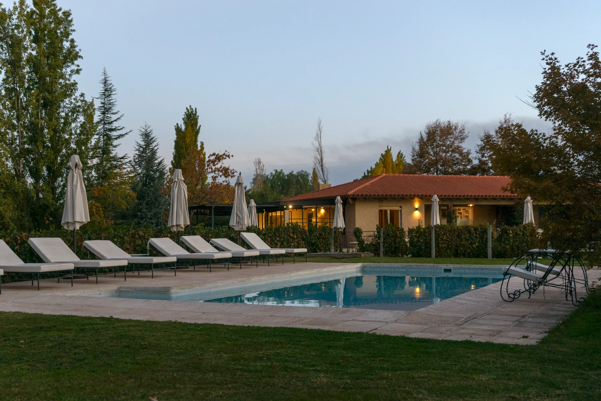The pool at dusk, with the main building lit behind