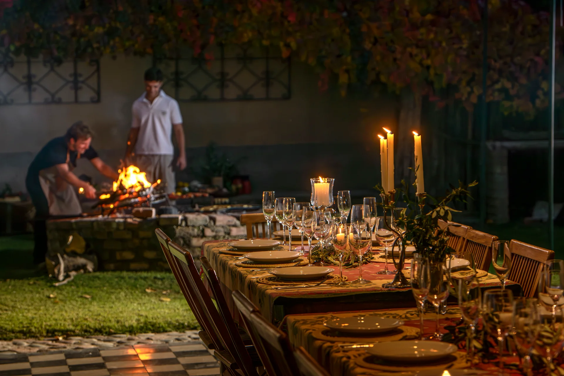 The long table set by candlelight while the fire is worked at Abrasa Viva